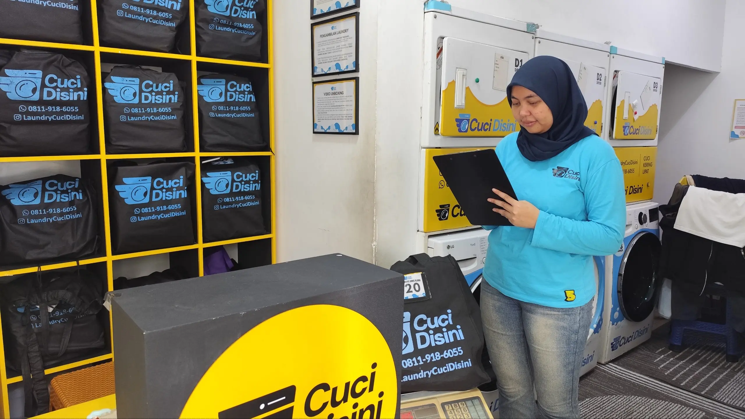 Staff mencatat data laundry pelanggan