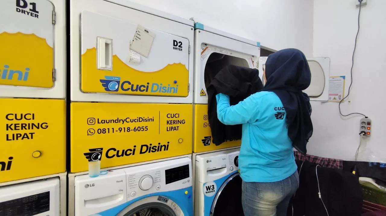 Staff memasukkan cucian ke mesin