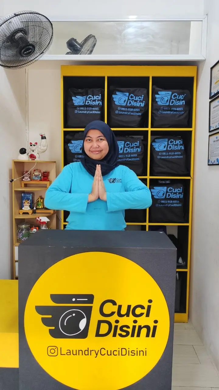 Staff Cuci Disini menyambut pelanggan di outlet