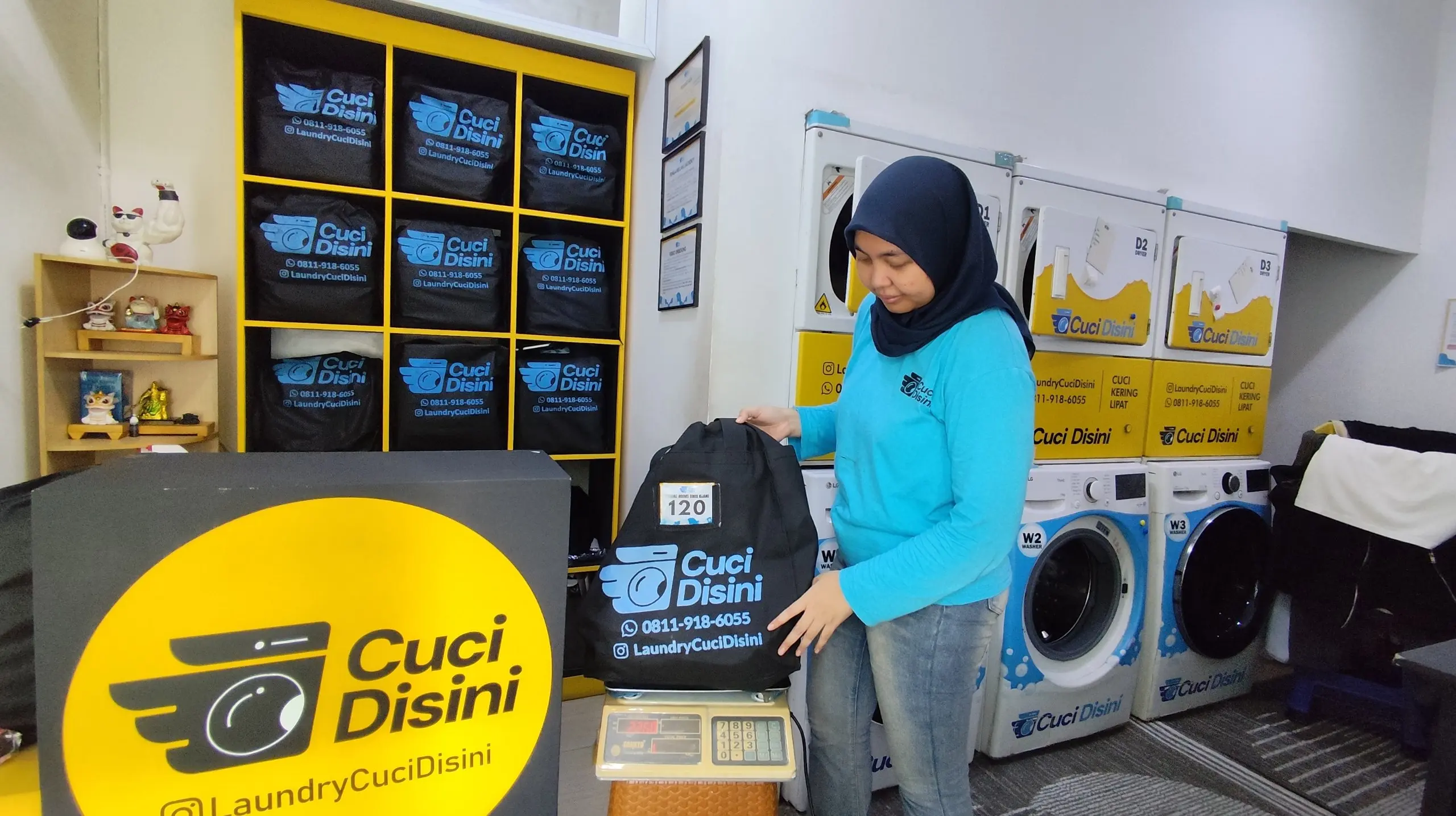 Staff menimbang cucian langsung di outlet